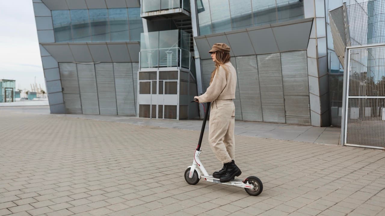 Kobieta jadąca hulajnogą elektryczną
